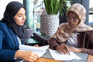 serious-female-colleagues-studying-documents-cafe